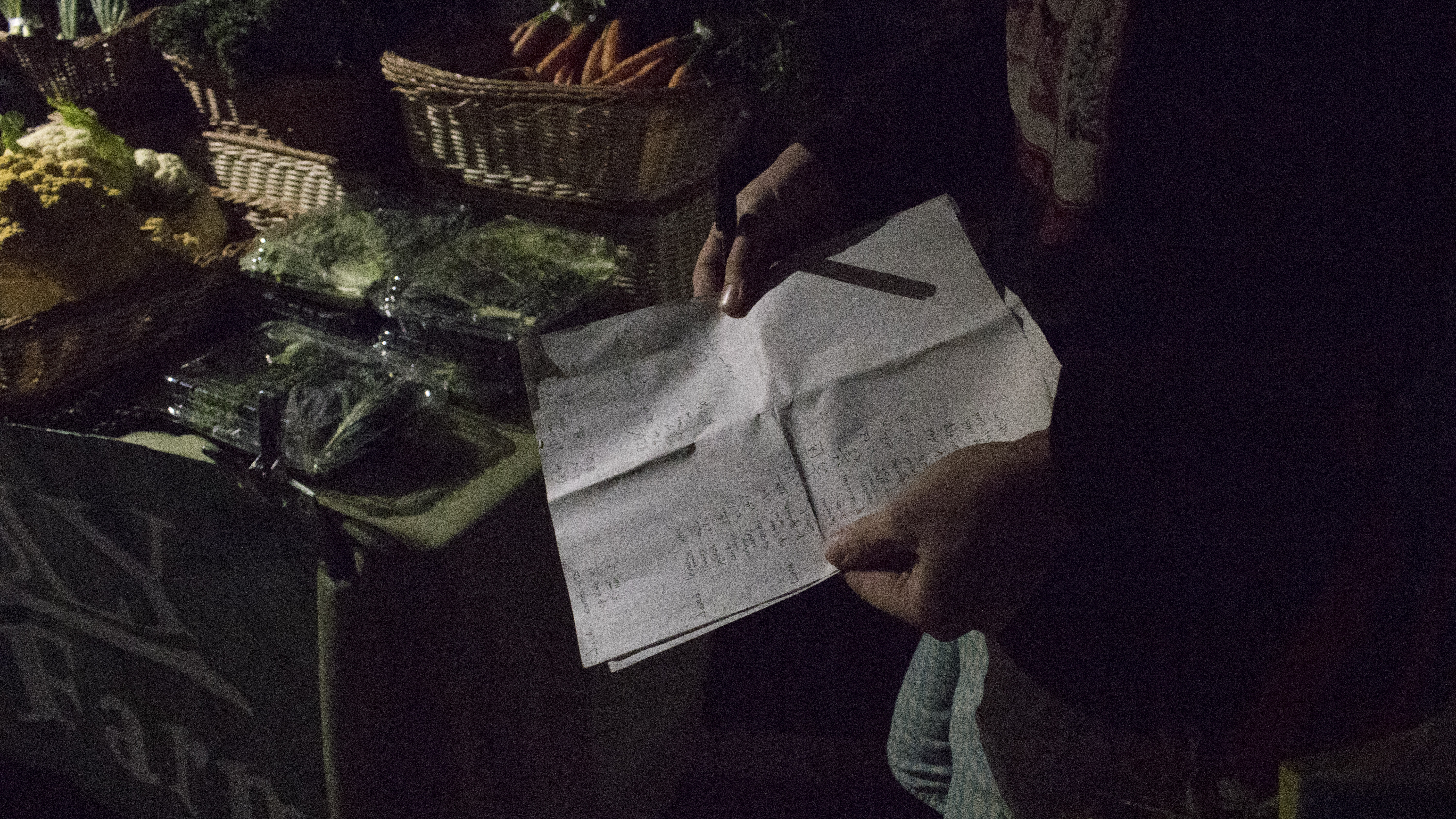Joey Lyman references his grocery list with customer orders written down | Photo Credit: Megan Lynch
