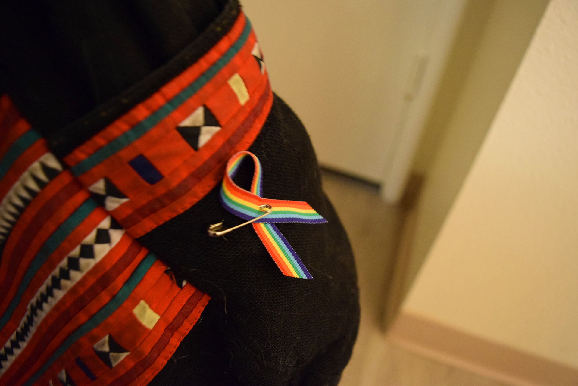 Though the travel ban will be well-covered in future pieces, another important facet to the present-day culture of LGBTQ+ students at Cal Poly is the prevalence of allies. Spotted here on the backpack of nutrition major and fourth year Spalding Bristow is the rainbow ribbon pin given out in 2017-18 by the Queer Student Union and PRISM programs to advocate for LGBTQ+ youth acceptance and public display of ally sentiment. Bristow says “...it must be awful not feeling safe to fully be yourself, and I wanted to show that I support all love.” 
Photo Credit: Katelyn Biddle