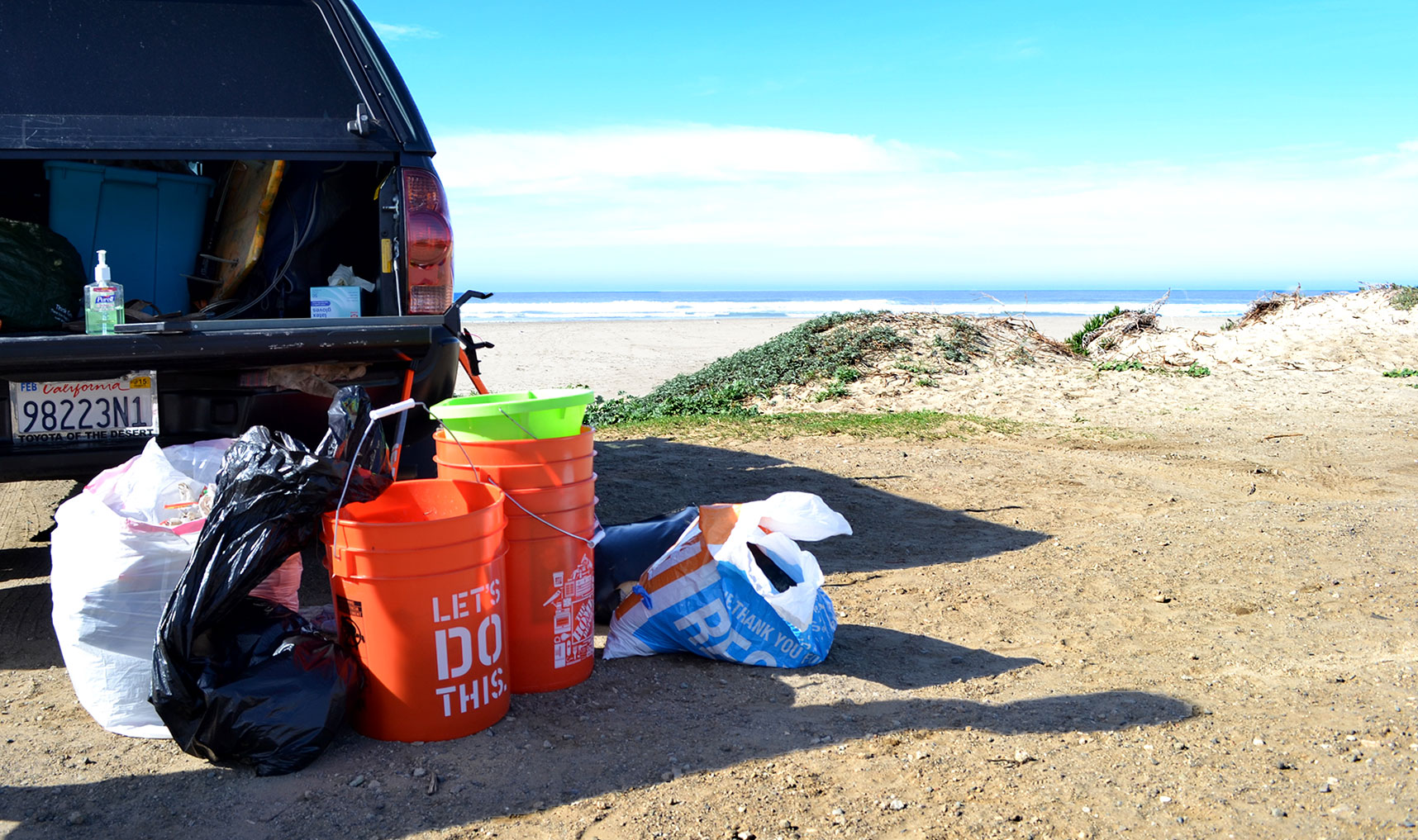 Equipment provided by the club’s parent organization Surfrider Foundation, such as buckets and trash pick-up tools, sit next to the filled trash bags. Once all the litter has been collected, the bags are counted and loaded up in club members' trucks to be disposed of. The Surfriders chat about the cleanup before parting ways and agreeing to see each other at the next club meeting during the upcoming week. 
